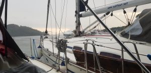 Photo of yachts moored up side-by-side with island in the background and grey skies