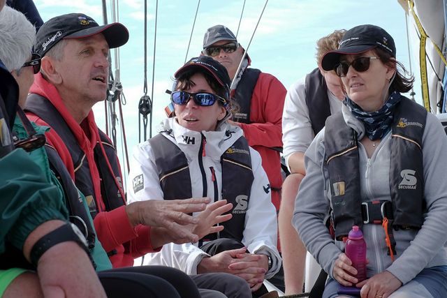 Robert giving instruction to a yacht crew of 5 sailors all wearing life jackets