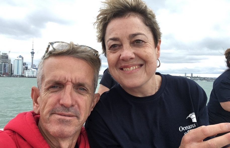 Robert and Ingrid smiling to camera with a city scape from New Zealand in the background