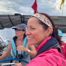 Image of Judy Campbell in a pink sailing jacket on board a yacht