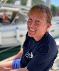 Image of Judy wearing an Oceans of Hope dark blue tee shirt and smiling