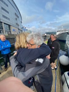 Two sailors embrace after getting off the boat in Belfast